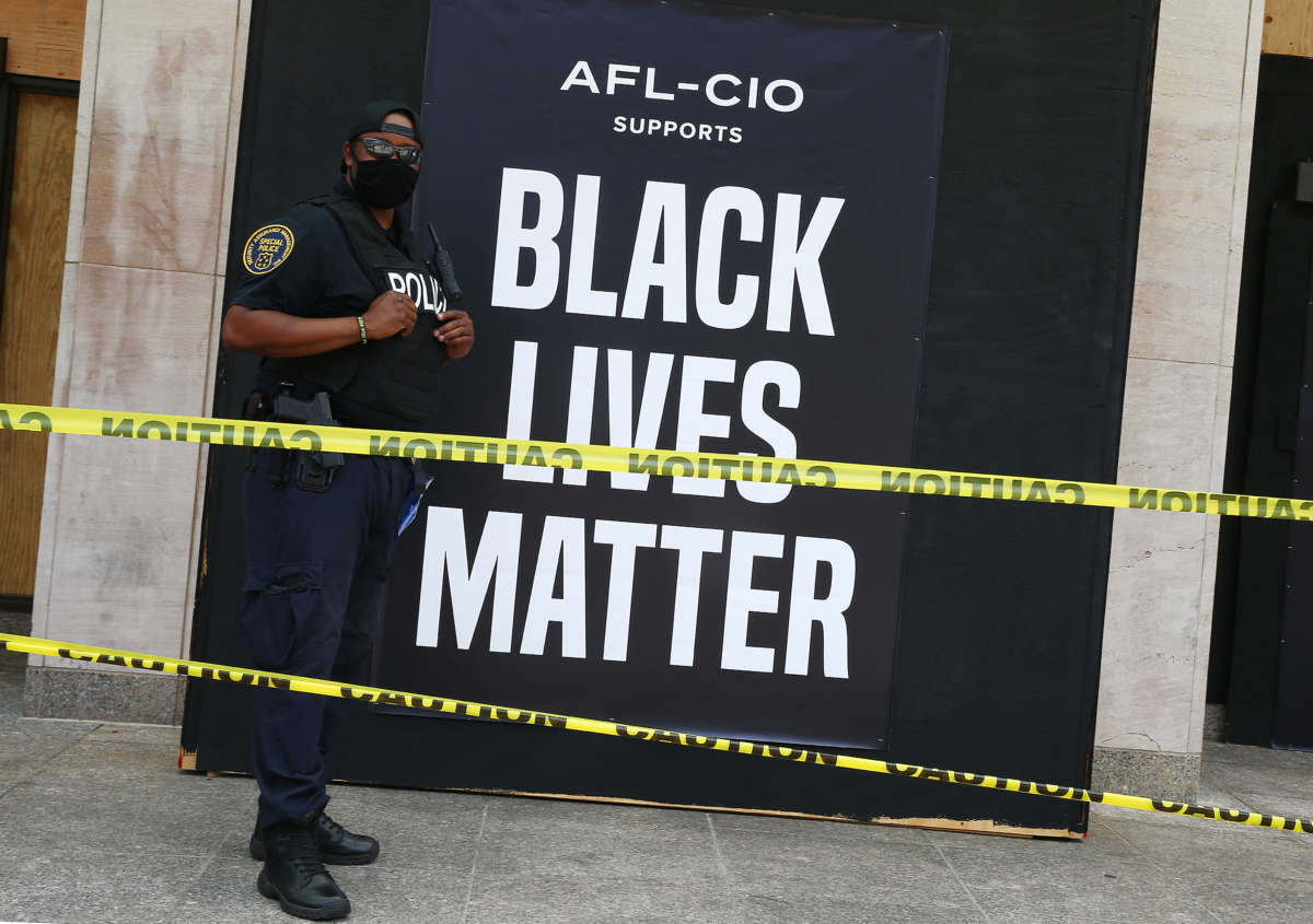 A security guard stands watch at the AFL-CIO union headquarters as a protest against police brutality and racism takes place on June 6, 2020, in Washington, D.C.