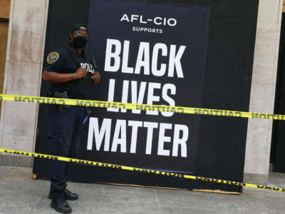 A security guard stands watch at the AFL-CIO union headquarters as a protest against police brutality and racism takes place on June 6, 2020, in Washington, D.C.