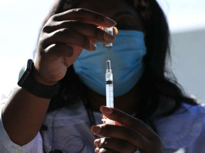 D.C. Health Nurse Manager Ashley Hennigan fills a syringe with a dose of the Johnson & Johnson coronavirus vaccine during a walk-up clinic at the John F. Kennedy Center for the Performing Arts' outdoor Reach area on May 6, 2021 in Washington, D.C.