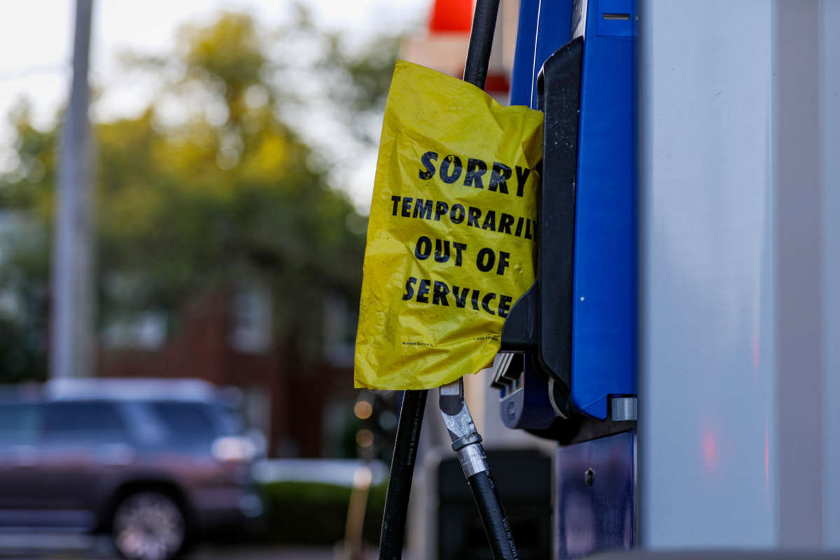 A yellow bag reading "SORRY; TEMPORARILY OUT OF SERVICE" covers a gas pump