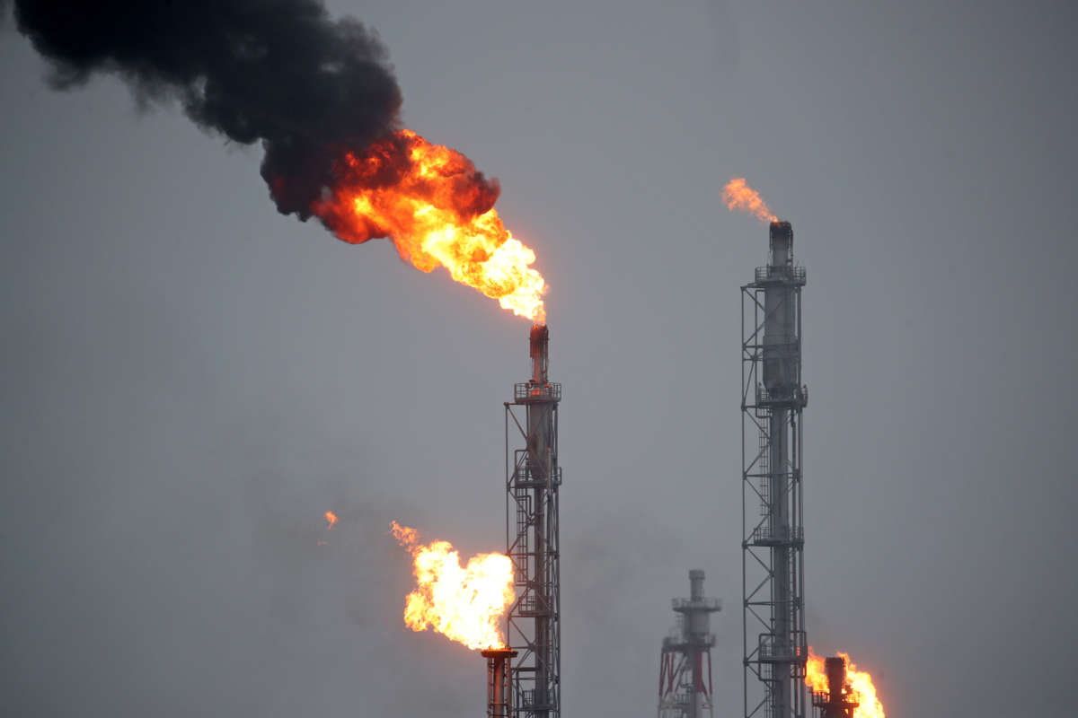 Fire shoots from the top of smokestacks