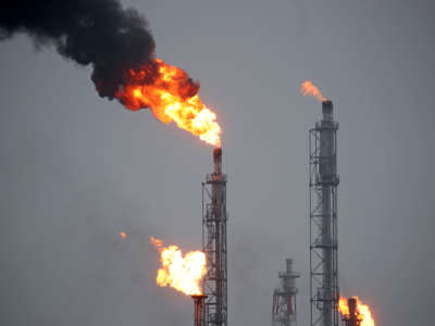 Fire shoots from the top of smokestacks