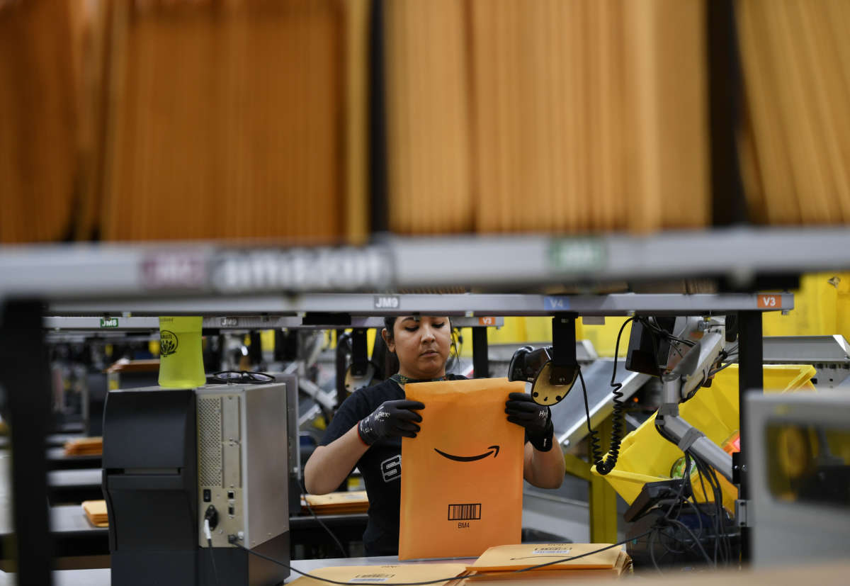 A worker prepares amazon packages in a warehouse