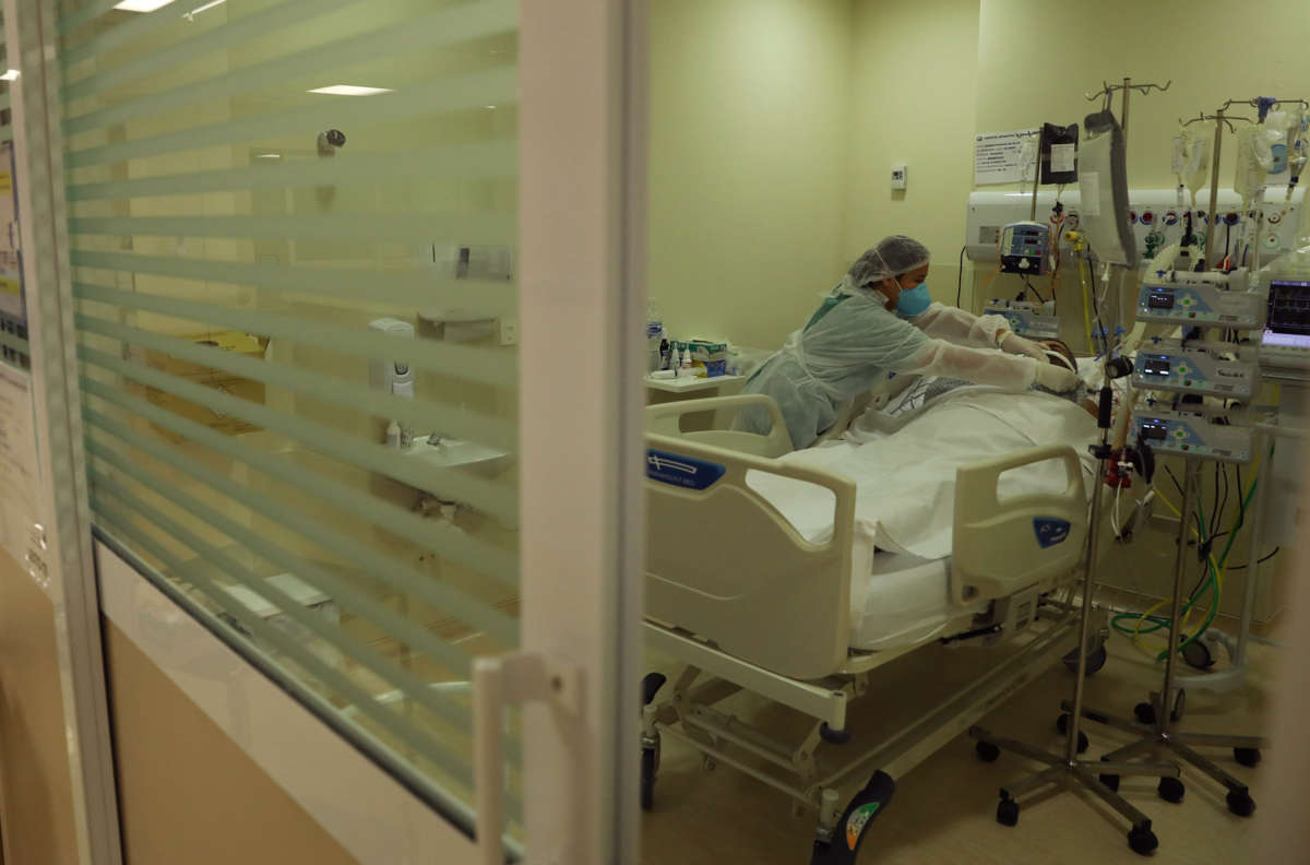 An intensive care medical staffer, protected by PPE, tends to a patient infected with COVID-19 at Municipal Hospital of Parelheiros on June 18, 2021, in Sao Paulo, Brazil