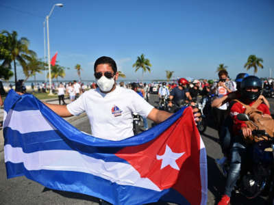 A man holds a Cuban flag during a protest calling for the end of the U.S. blockade against Cuba in Cienfuegos province, Cuba, on May 30, 2021.
