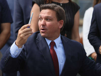 Florida Gov. Ron DeSantis gives away a pen after holding a bill signing ceremony at the Florida National Guard Robert A. Ballard Armory on June 7, 2021, in Miami, Florida.
