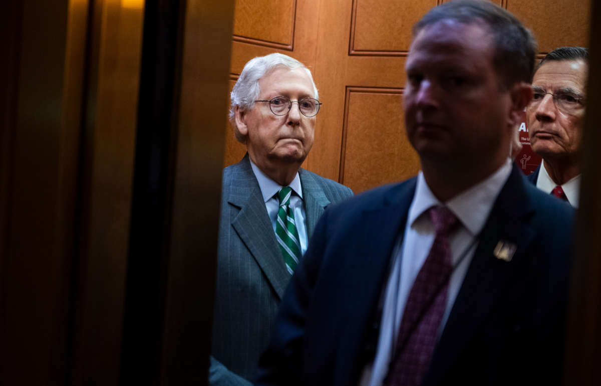 Senate Minority Leader Mitch McConnell, left, and John Barrasso, right, make their way to a news conference in the Capitol on June 17, 2021.