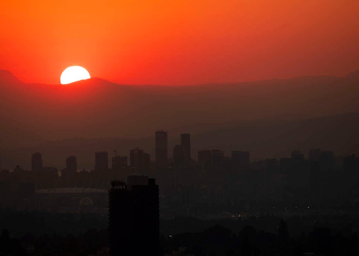 The sun sets on a city in the mountains