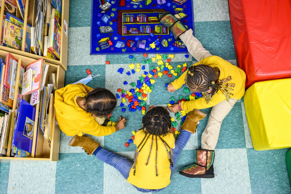 Three children play together at the Little Flowers Early Childhood and Development Center located in the Sandtown-Winchester neighborhood of Baltimore, Maryland, on January 11, 2021.