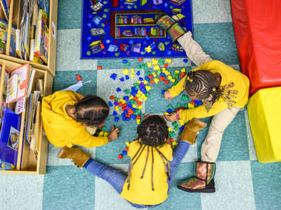 Three children play together at the Little Flowers Early Childhood and Development Center located in the Sandtown-Winchester neighborhood of Baltimore, Maryland, on January 11, 2021.