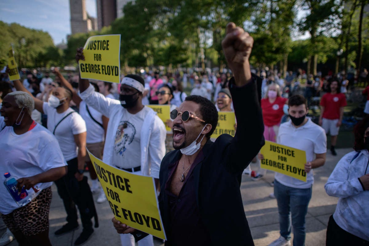 Black Lives Matter protesters hold placards and shout slogans during a march on the anniversary of the death of George Floyd, in Brooklyn, New York, on May 25, 2021.