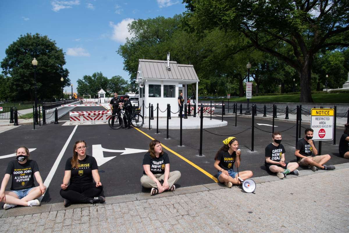 Protesters with the Sunrise Movement block a vehicle entrance at the White House as they demonstrate against what they say is slow action on infrastructure legislation, job creation and addressing climate change, as well as against attempts to compromise with Senate Republicans in Washington, D.C., on June 4, 2021.