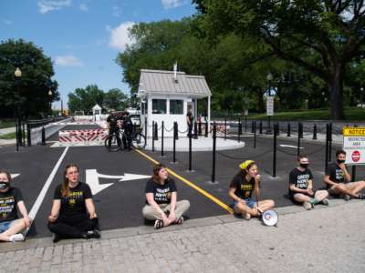 Protesters with the Sunrise Movement block a vehicle entrance at the White House as they demonstrate against what they say is slow action on infrastructure legislation, job creation and addressing climate change, as well as against attempts to compromise with Senate Republicans in Washington, D.C., on June 4, 2021.
