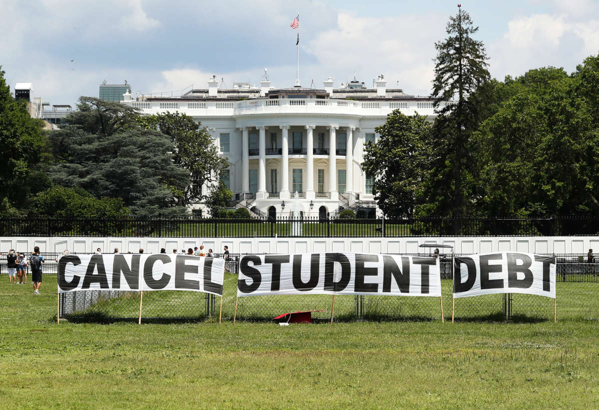 As college students around the country graduate with a massive amount of debt, advocates display a hand-painted sign on the Ellipse in front of The White House to call on President Joe Biden to sign an executive order to cancel student debt on June 15, 2021, in Washington, D.C.
