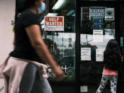 People walk by a Help Wanted sign in the Queens borough of New York City on June 4, 2021, in New York City.