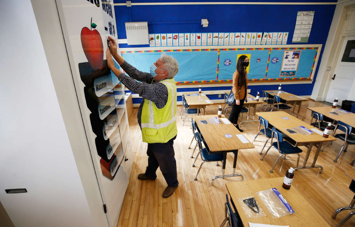 Randy Lemons, senior project manager for construction projects, secures a BARD HVAC unit in a kindergarten classroom at West Hollywood Elementary School on March 18, 2021, in West Hollywood, California.