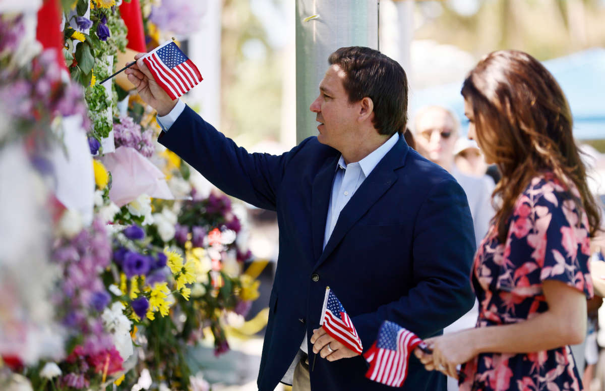 Florida Gov. Ron DeSantis and his wife, Casey, visit a memorial to those missing outside the 12-story Champlain Towers South condo building that partially collapsed on July 3, 2021, in Surfside, Florida.