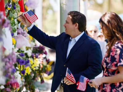 Florida Gov. Ron DeSantis and his wife, Casey, visit a memorial to those missing outside the 12-story Champlain Towers South condo building that partially collapsed on July 3, 2021, in Surfside, Florida.