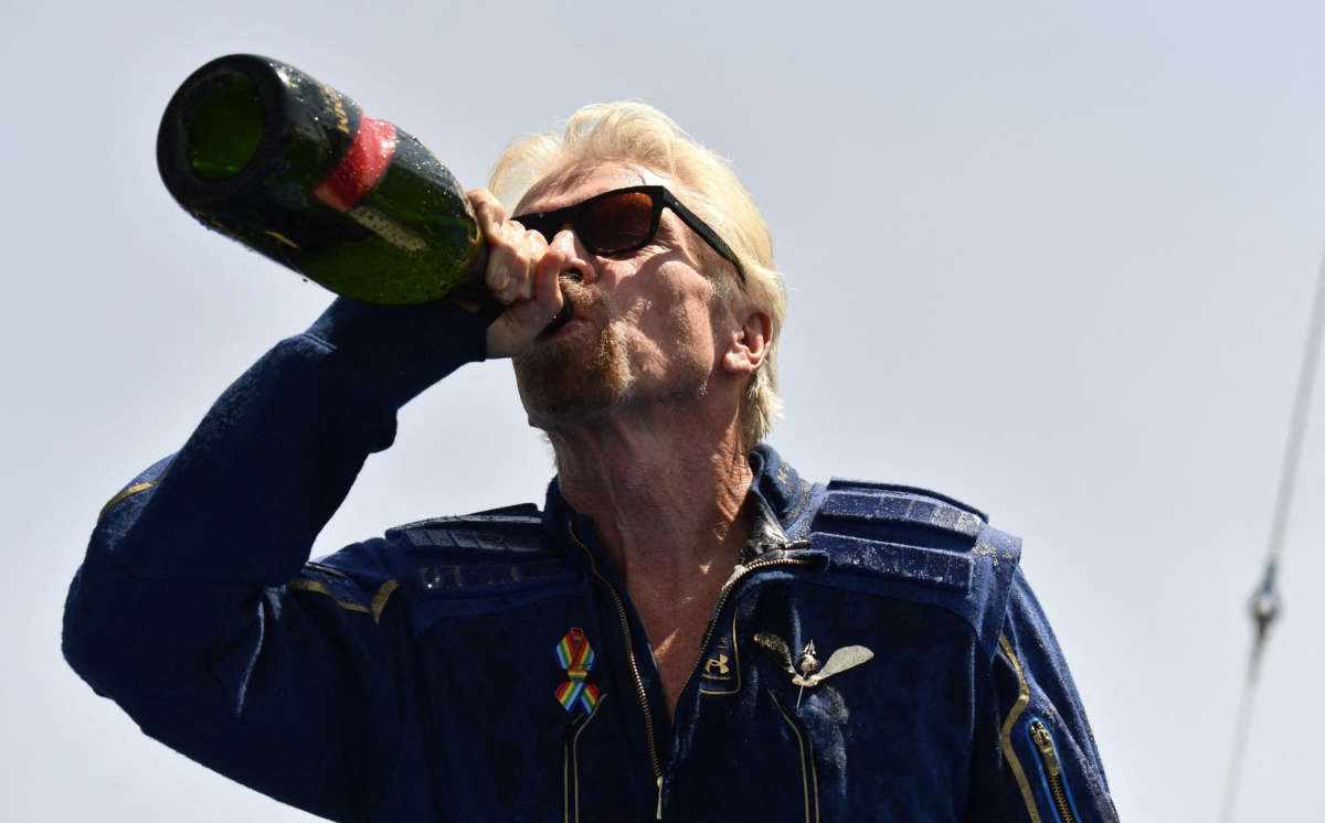 Virgin Galactic founder Sir Richard Branson drinks champagne with crew members after flying into space aboard a Virgin Galactic vessel, near Truth and Consequences, New Mexico, on July 11, 2021.