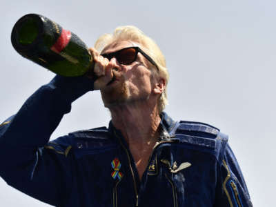 Virgin Galactic founder Sir Richard Branson drinks champagne with crew members after flying into space aboard a Virgin Galactic vessel, near Truth and Consequences, New Mexico, on July 11, 2021.