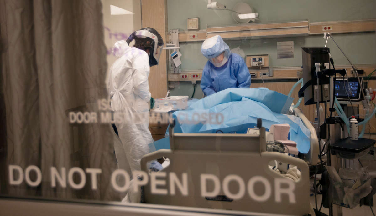 Medical workers help a patient in a hospital room