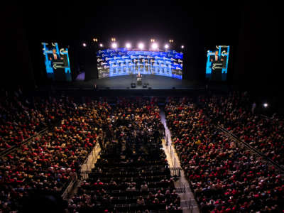 Donald Trump speaks to his audience, in an indoor venue