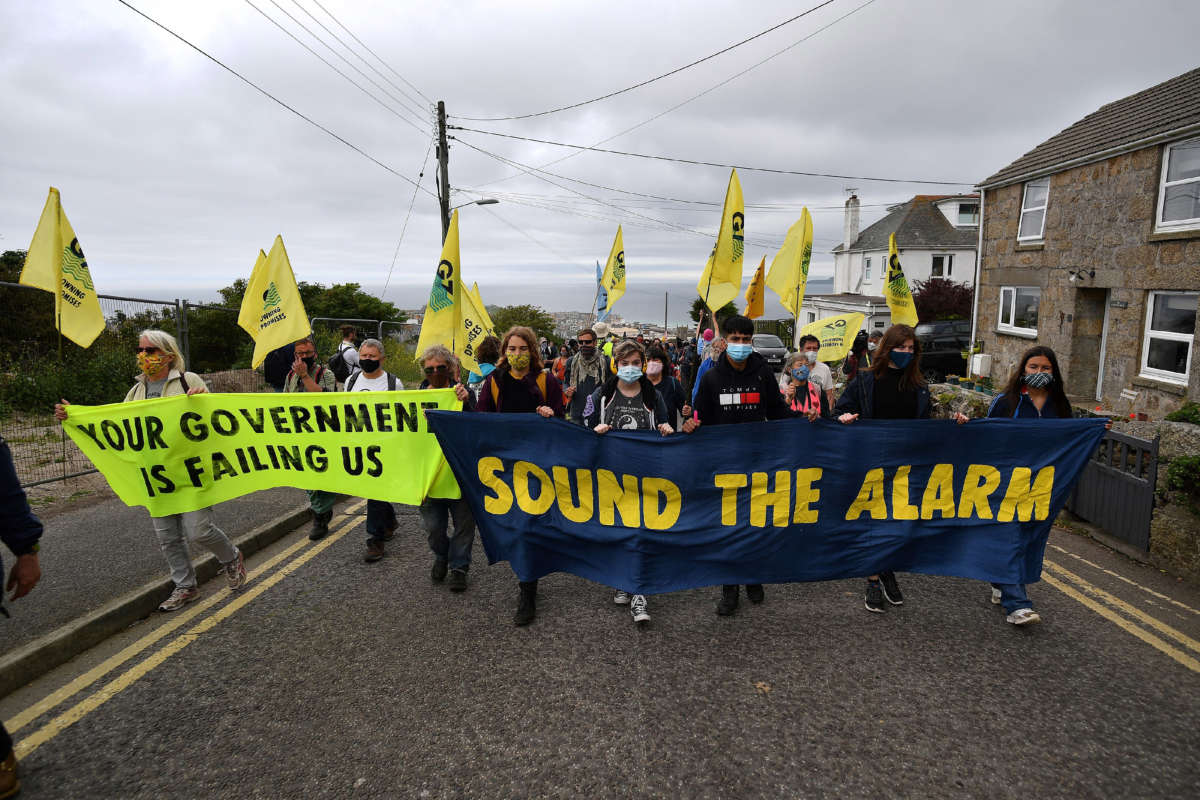 Activists from the climate change protest group Extinction Rebellion take part in a protest march in St. Ives, Cornwall, on June 11, 2021, on the first day of the three-day G7 summit being held from June 11-13.