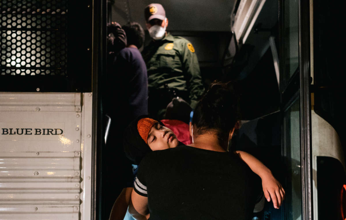 A migrant mother and son board a patrol bus to be taken to a border patrol processing facility after crossing the Rio Grande into the U.S. on June 21, 2021, in La Joya, Texas.