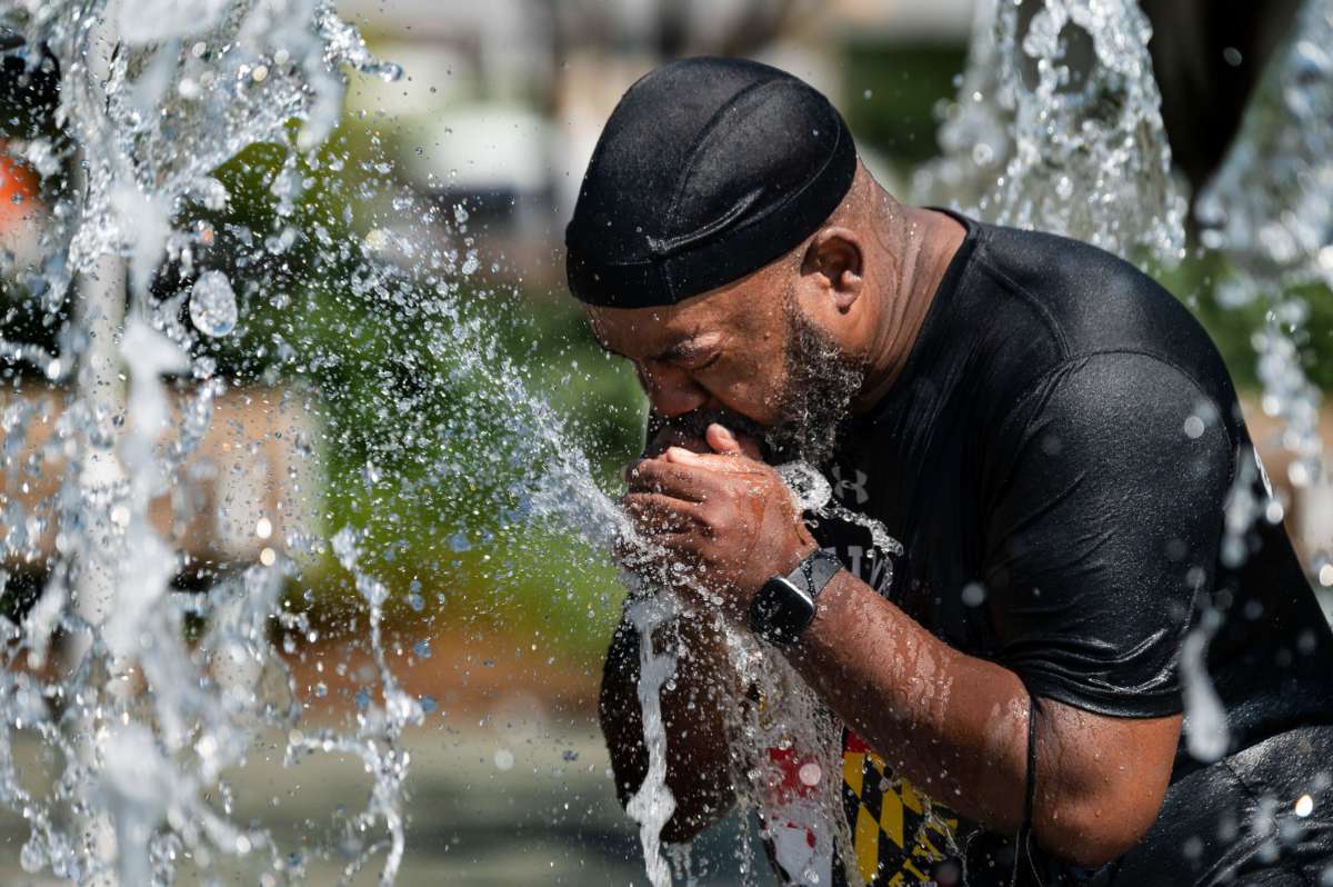 A man cools off in a fountain at the Inner Harbor in Baltimore, Maryland, on June 30, 2021, as a heat wave threatens to make it Baltimore's hottest day of the year.