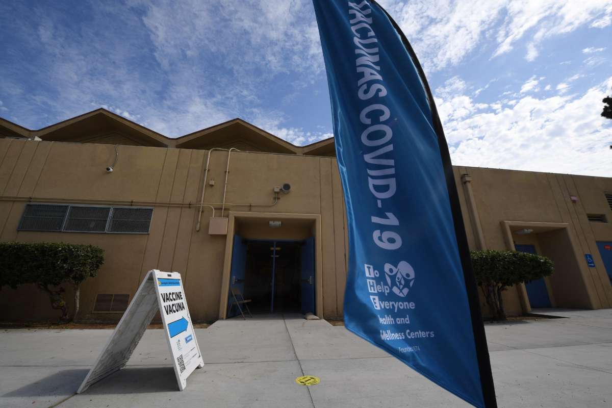 A sign points to a COVID-19 vaccination clinic offering the Pfizer vaccine to anyone over the age of 12 who wants it, at Crenshaw High School in the predominantly Latinx and Black neighborhood of South Los Angeles, on July 8, 2021. The clinic was empty except for the staff working there.