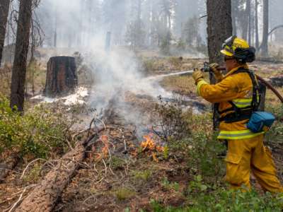 A firefighter out of California puts out hot spots on the Bootleg Fire north of Bly, Oregon, on July 17, 2021.