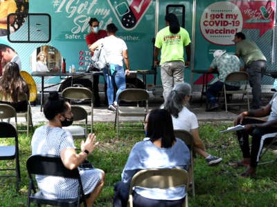 People wait in the observation area at a mobile COVID-19 vaccination site in Orlando, Florida, on July 21, 2021.