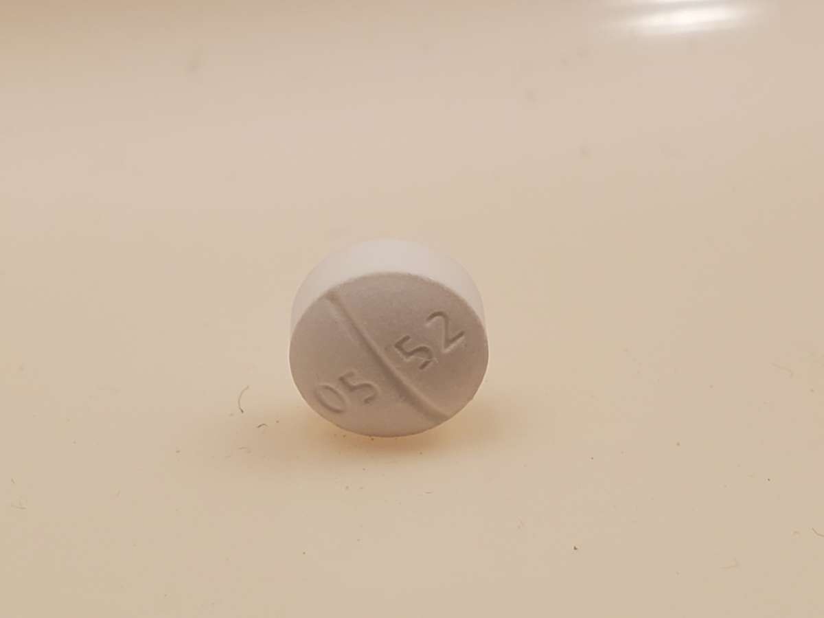 A close-up of a white Oxycodone Hydrochloride pill.