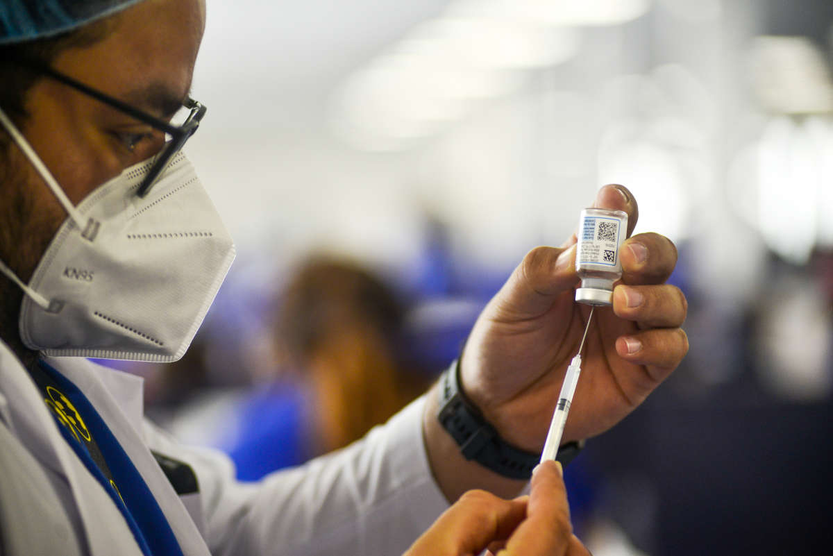 A medical worker fills a syringe with the moderna vaccine