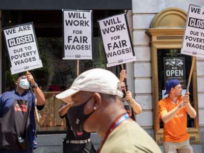 Activists take part in a protest outside of the Old Ebbitt Grill to call for a full minimum wage with tips for restaurant workers in Washington, D.C. on May 26, 2021.