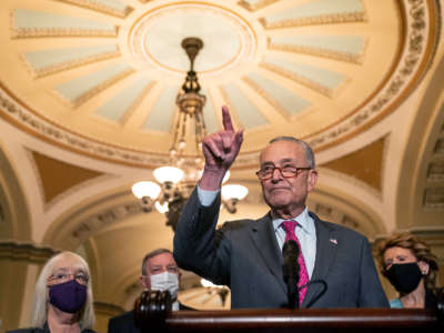 Chuck Schumer points at the ceiling