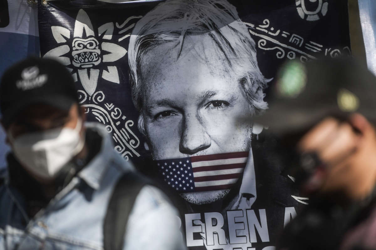 A painting of Julian Assange being gagged by the u.s. flag