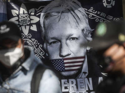 A painting of Julian Assange being gagged by the u.s. flag