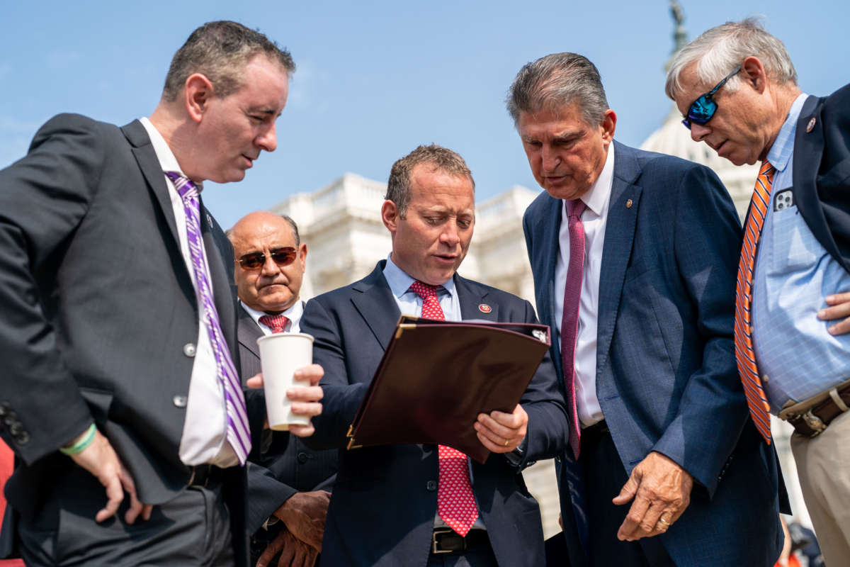 Rep. Brian Fitzpatrick (R-Pennsylvania), Rep. Josh Gottheimer (D-New Jersey), Sen. Joe Manchin (D-West Virginia), and Rep. Fred Upton (R-Michigan) talk before the Problem Solvers Caucus news conference on the Infrastructure Deal in front of the U.S. Capitol Building on Friday, July 30, 2021.