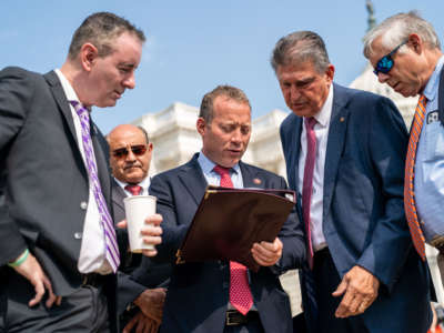 Rep. Brian Fitzpatrick (R-Pennsylvania), Rep. Josh Gottheimer (D-New Jersey), Sen. Joe Manchin (D-West Virginia), and Rep. Fred Upton (R-Michigan) talk before the Problem Solvers Caucus news conference on the Infrastructure Deal in front of the U.S. Capitol Building on Friday, July 30, 2021.