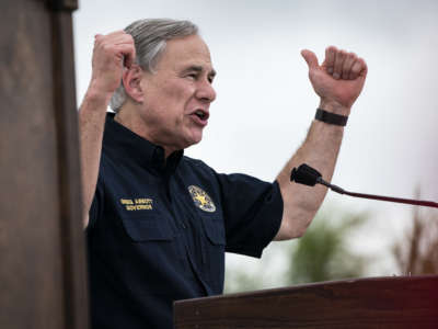 Greg Abbott pumps his arms at a rally