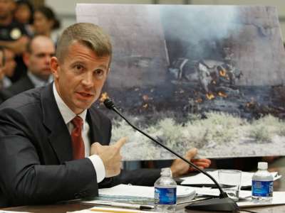 Erik Prince holds up a picture showing the affect of a car bomb while testifying during a House Oversight and Government Reform Committee hearing on Capitol Hill October 2, 2007 in Washington, D.C.