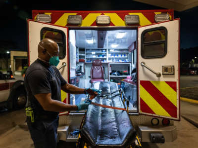 A Houston Fire Department EMS medics disinfect a stretcher after delivering a patient to a Covid-19 overflow area at Memorial Herman Northeast Hospital on August 19, 2021 in Houston, Texas.