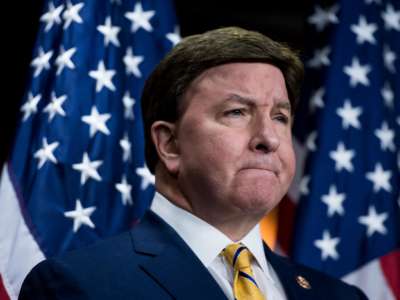 Mike Rogers stands in front of a u.s. flag