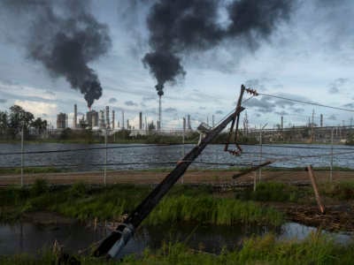 Broken power lines, destroyed by Hurricane Ida, are seen along a highway near a petroleum refinery on August 30, 2021 outside LaPlace, Louisiana.