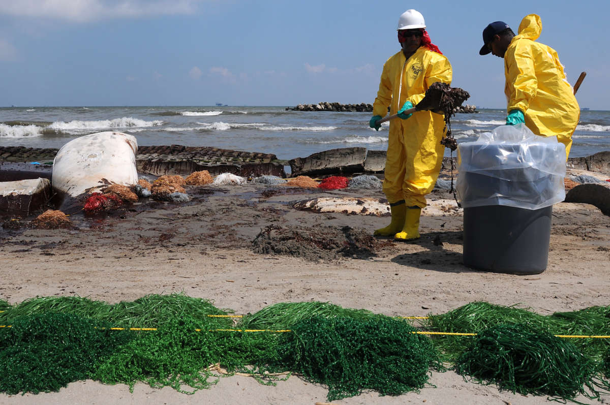 Members of a U.S. Coast Guard Shoreline Cleanup and Assessment Team remove oil from a beach in Port Fourchon, Louisiana, in May 2010. Gulf Coast residents and response workers were exposed to the toxic mix of oil and chemical dispersants used to clean up the massive oil spill. Many suffer from chronic illness and other debilitating health impacts as a result.