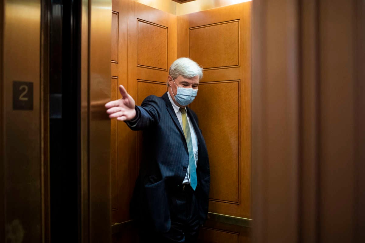 Sen. Sheldon Whitehouse holds open an elevator door as he makes his way to the Senate floor for a vote in the Capitol in Washington, D.C., on June 17, 2020.