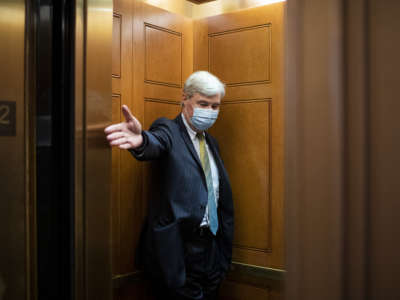 Sen. Sheldon Whitehouse holds open an elevator door as he makes his way to the Senate floor for a vote in the Capitol in Washington, D.C., on June 17, 2020.