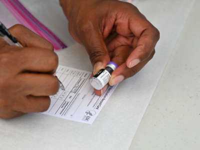 A health care worker fills out a COVID-19 vaccination card at a community event in Los Angeles, California, on August 11, 2021.