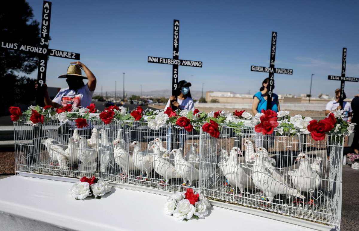 Twenty three doves await release outside Walmart as mourners hold crosses honoring those killed in the Walmart shooting which left 23 people dead in a racist attack targeting Latinx people on August 3, 2020, in El Paso, Texas.